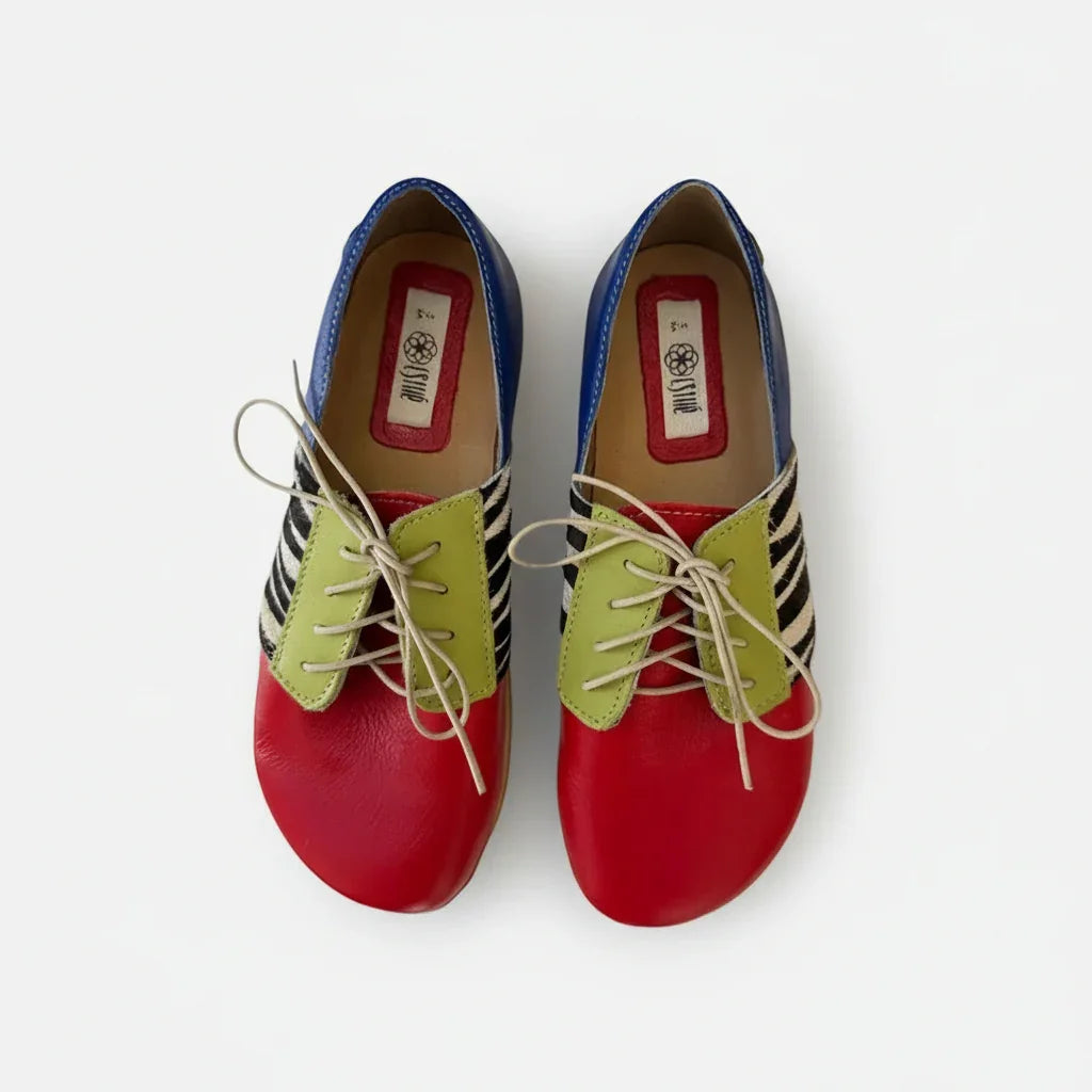 Colorful barefoot shoes with red toes, green laces, blue sides, and zebra stripe accents