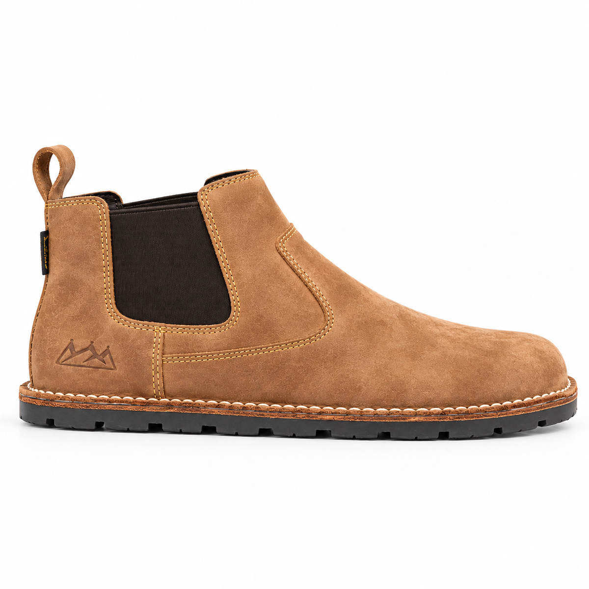 A tan suede Chelsea boot with a black elastic side panel, black sole, and a small mountain logo embossed on the heel, shown in profile against a white background.