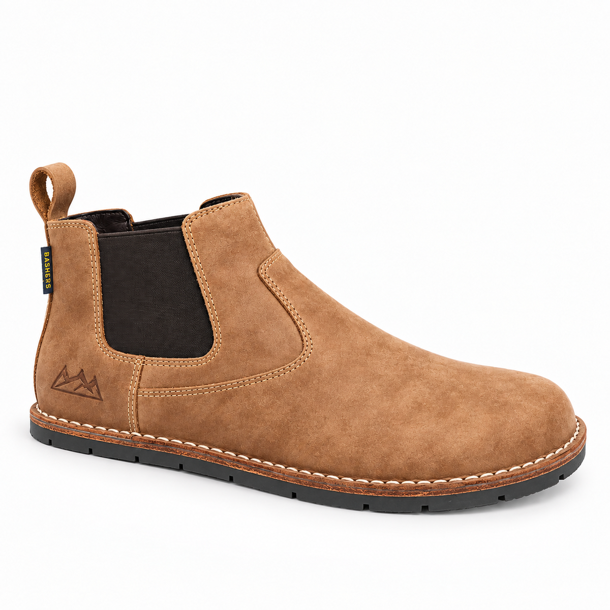 A tan suede Chelsea boot with a black elastic side panel, a pull tab, and a black sole, shown from a three-quarters angle on a white background.
