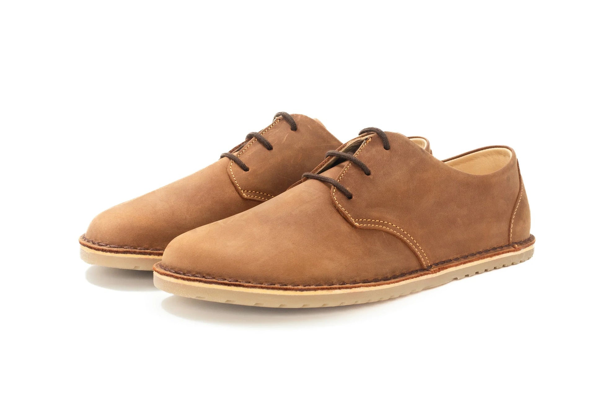 Pair of brown leather casual shoes with dark brown laces and beige rubber soles on white background