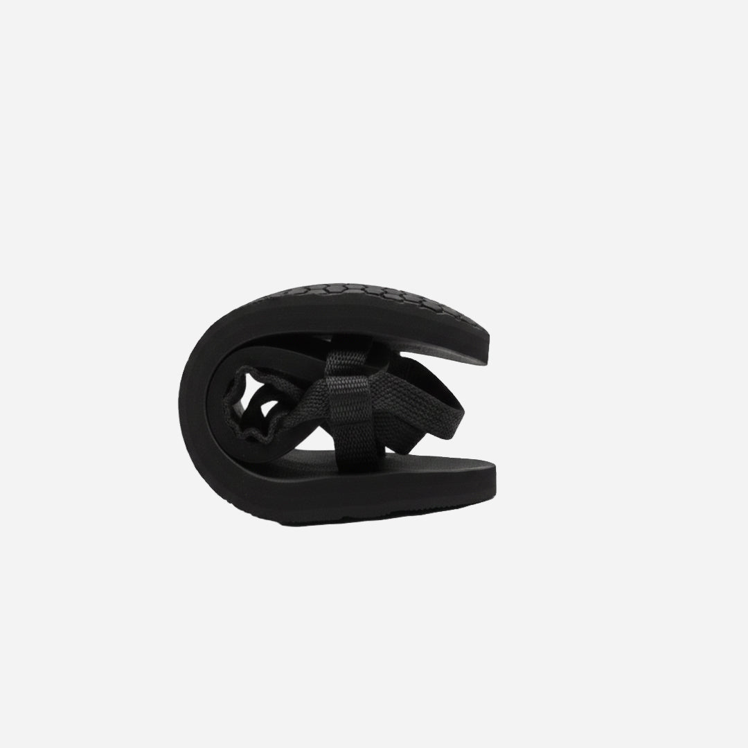 Black folded sandal showing flexibility on a white background