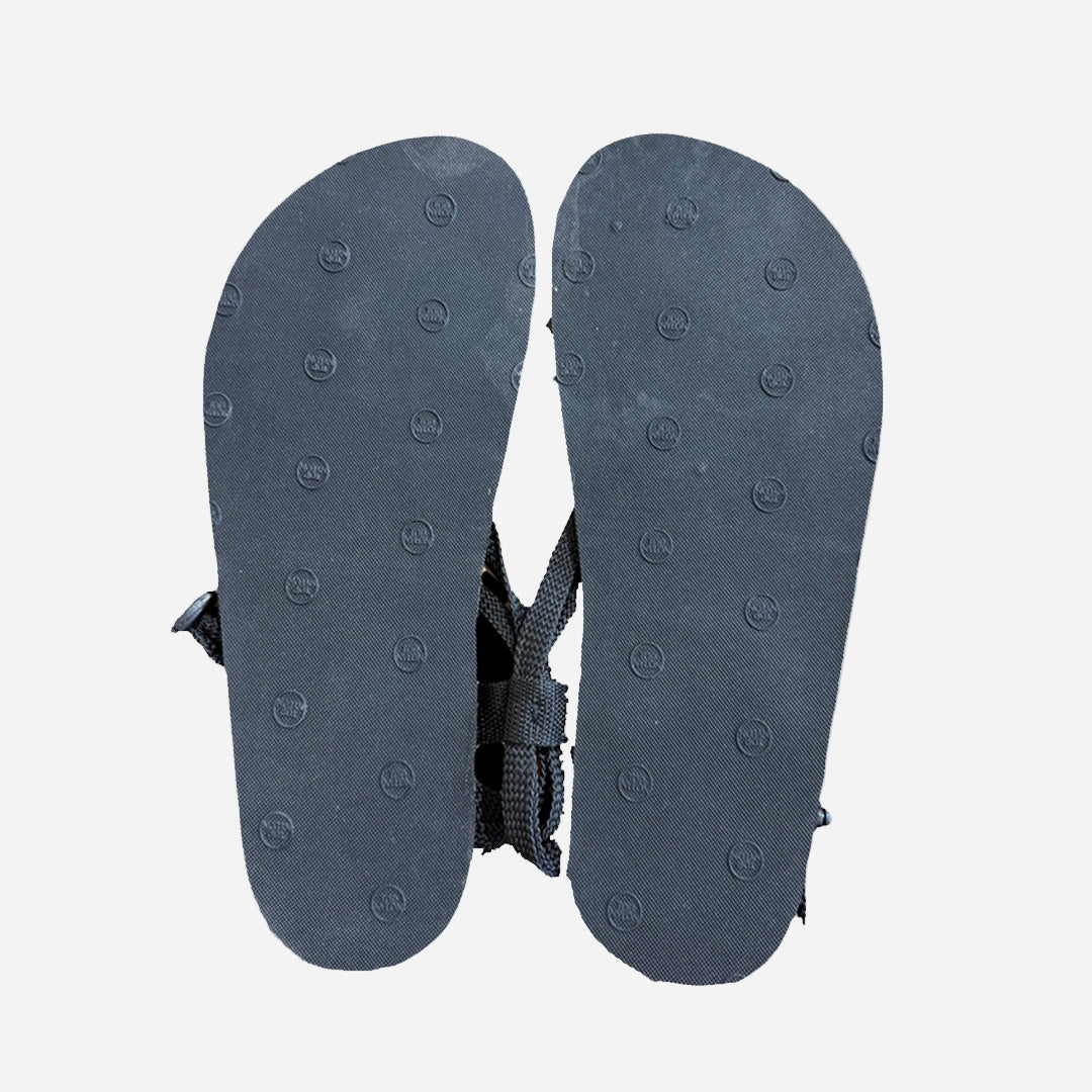 Black sandal sole with nylon lacing on a white background