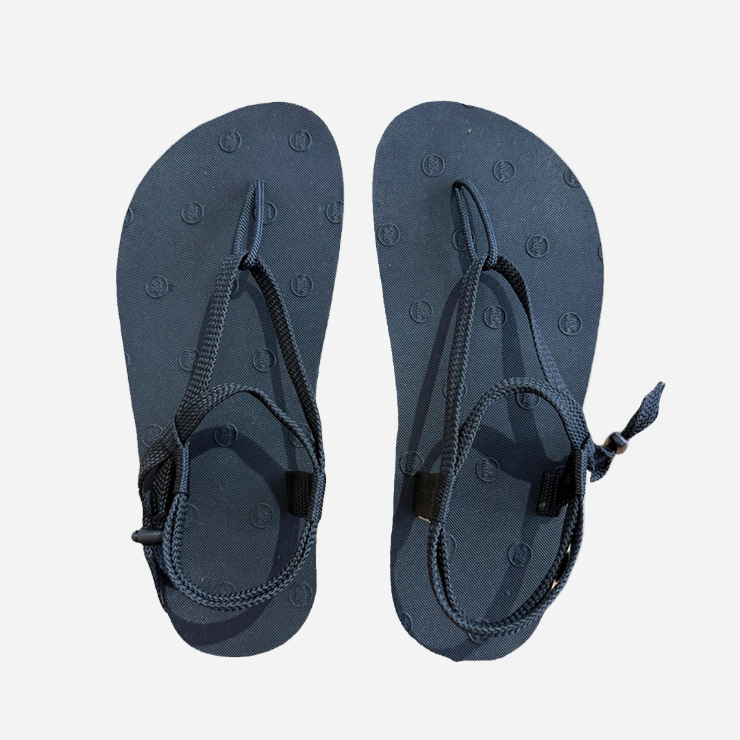 Pair of black sandals with black nylon laces on a white background