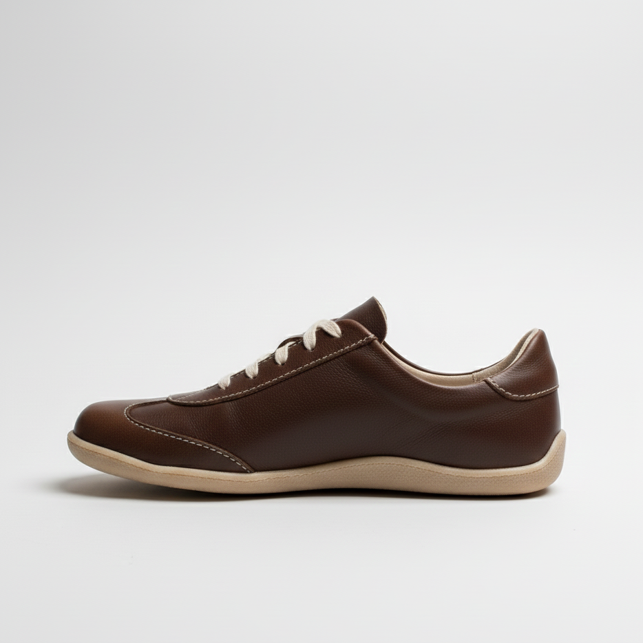 Brown sneaker with white laces on a light gray background