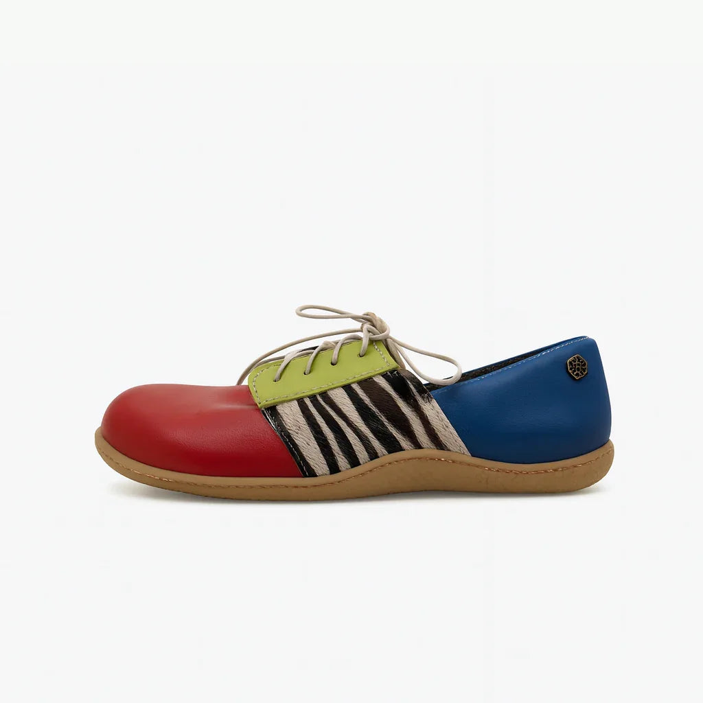 Colorful barefoot shoe with red toe, blue heel, green accent, zebra pattern, and tan sole