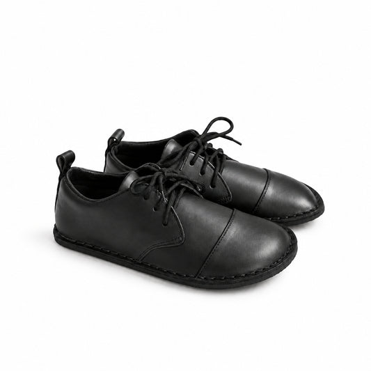 A pair of black leather lace-up shoes with a cap toe and decorative stitching, shown on a clean white background.