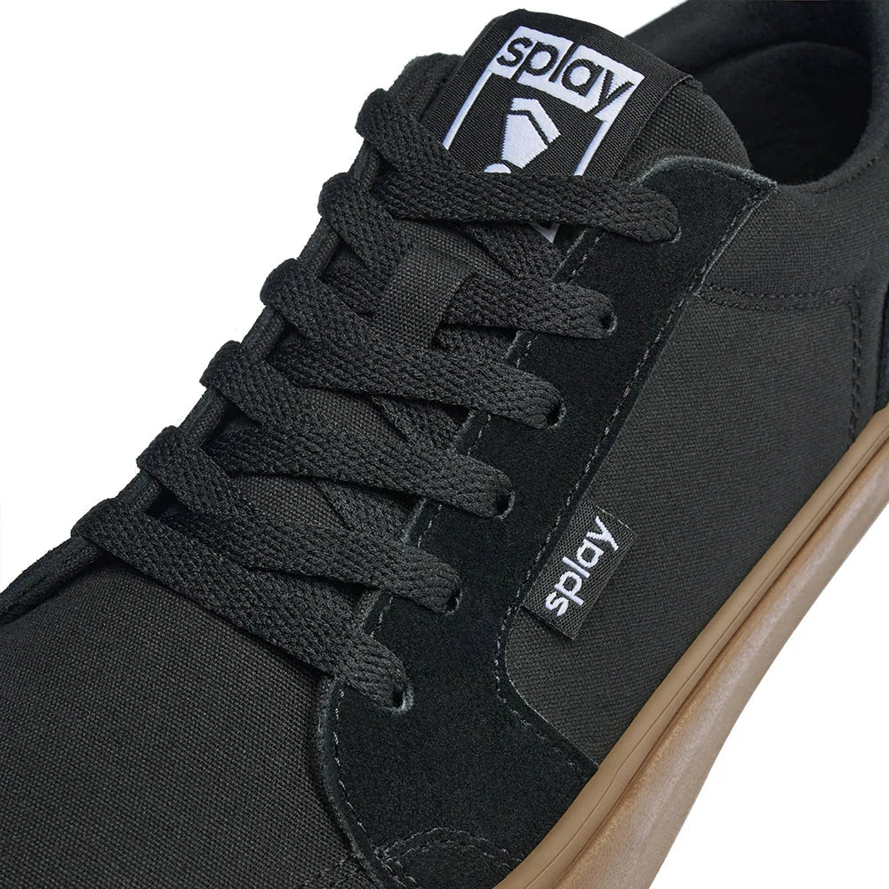 Close-up of black Splay Amsterdam sneaker with textured black laces and gum sole