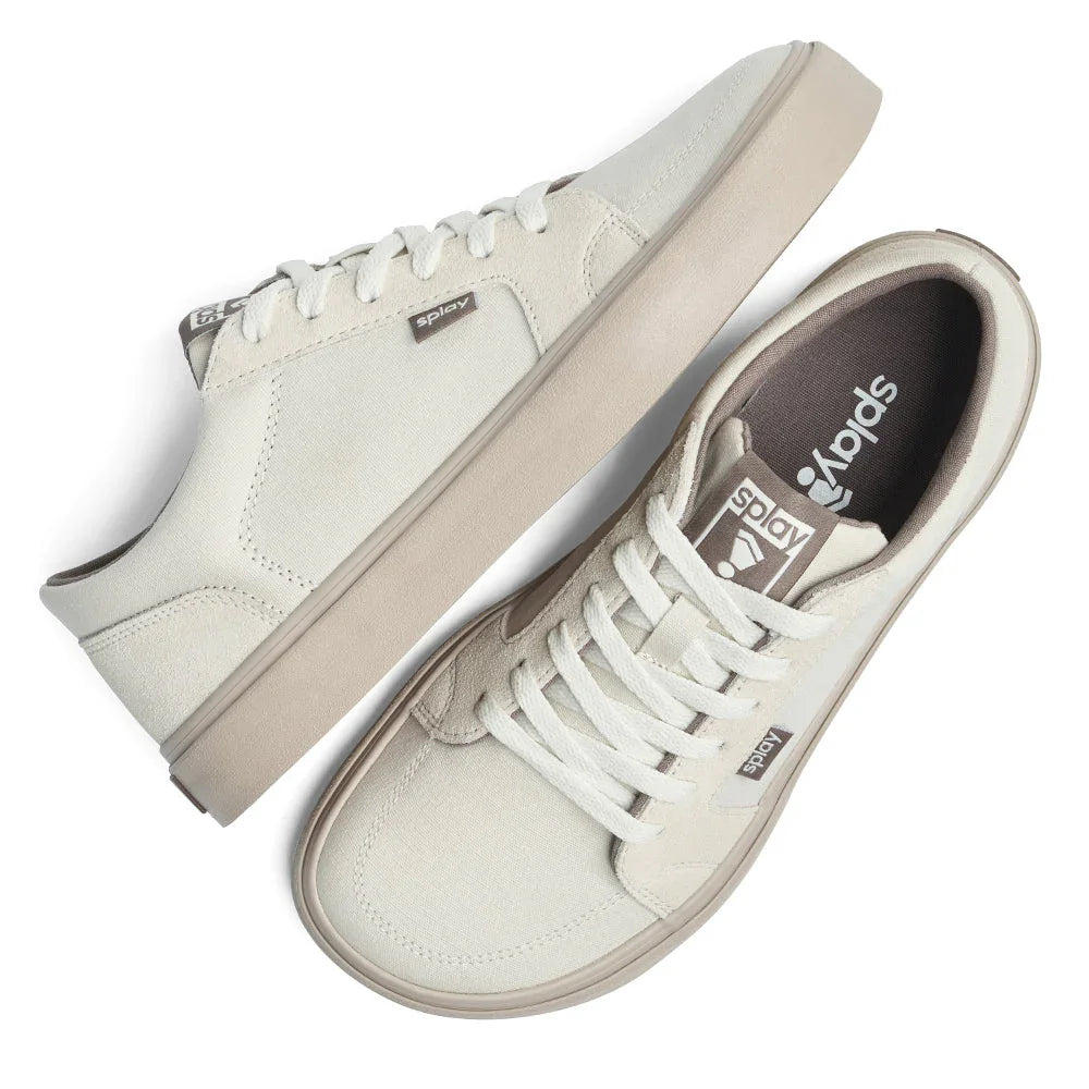 pair of off-white canvas casual sneakers with white laces and brown logo tags on top and side