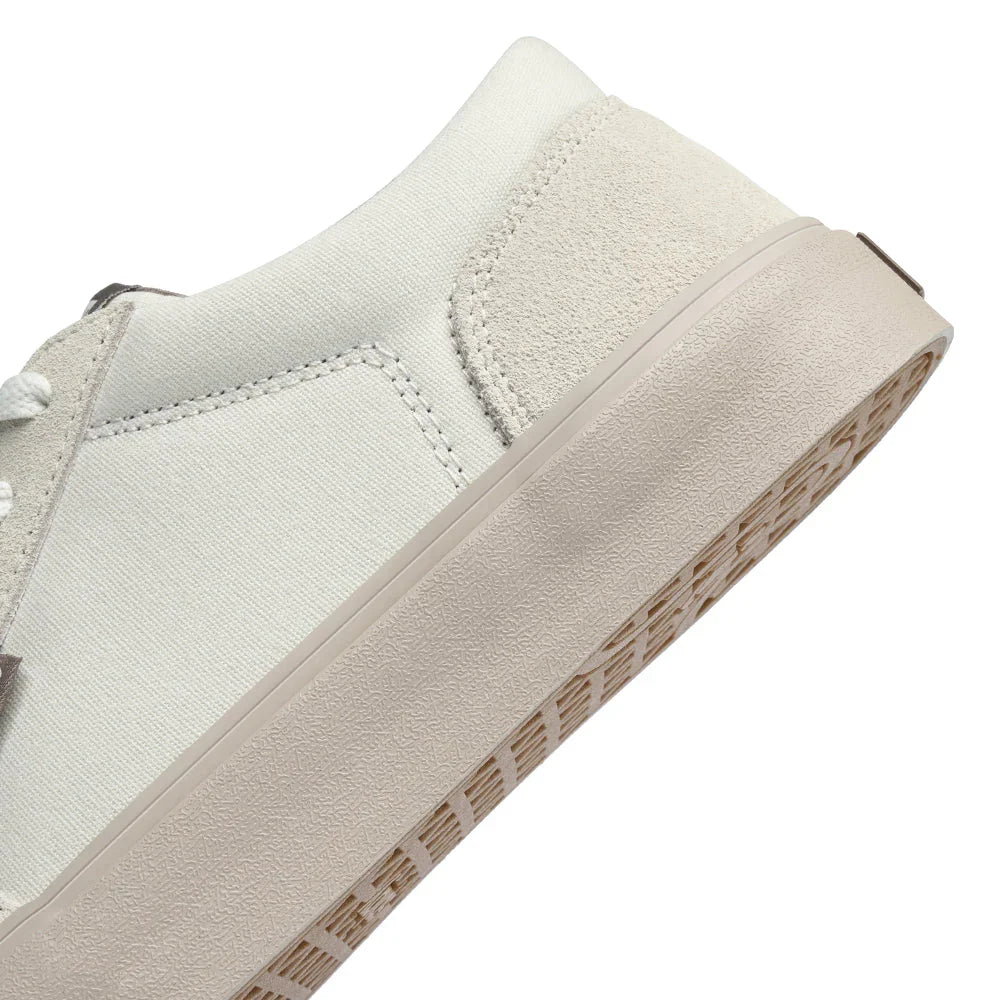 Close-up of white REV LT Barcelona sneaker with textured sole and suede heel detail