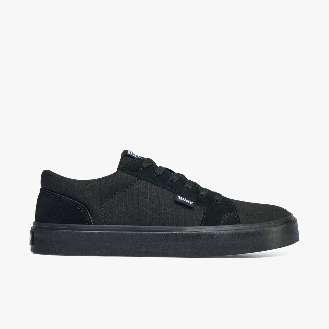 Side view of black low-top canvas sneaker with rubber sole and splay logo tag