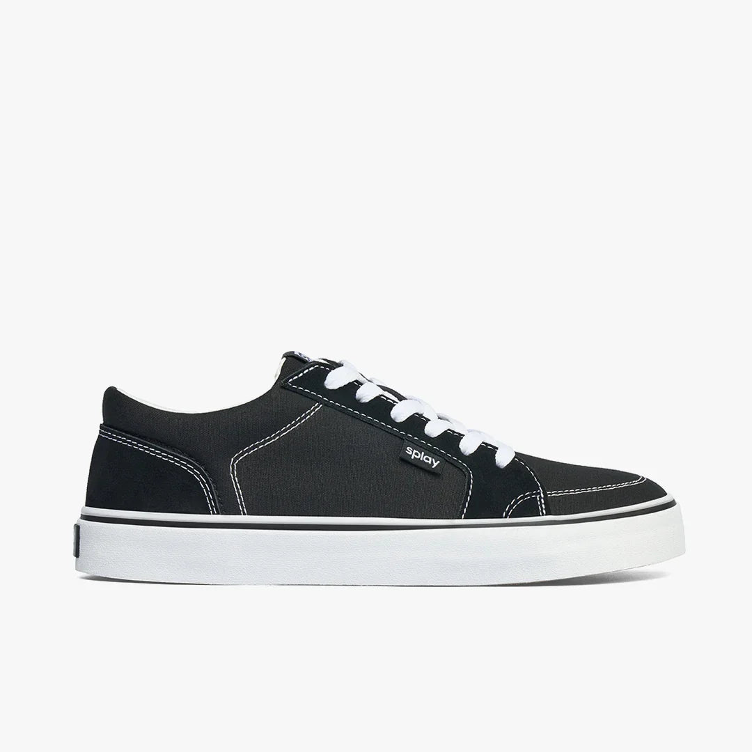 Black and white casual sneaker with white laces, thick sole, and contrast stitching