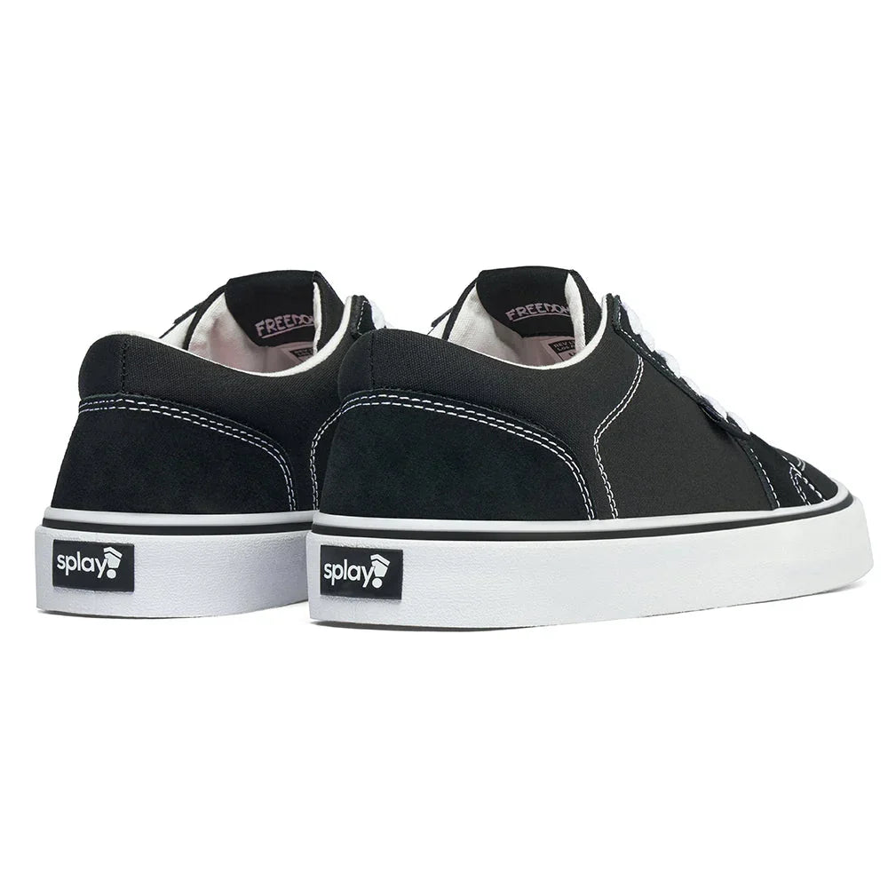 Black low-top canvas sneakers with white stitching and thick white rubber sole