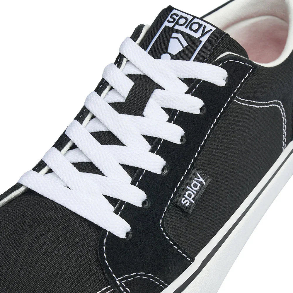 Black canvas Splay sneaker with white laces, white stitching, and rubber sole close-up