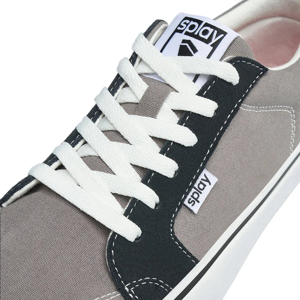Close-up of gray and black canvas casual sneaker with white laces and branding tags