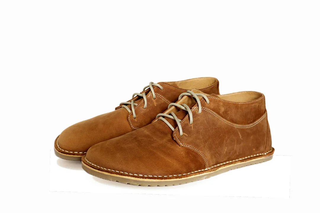 Pair of brown leather casual lace-up shoes with light stitching on white background