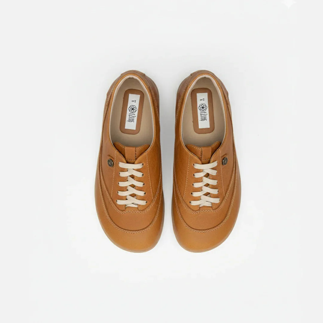 Pair of tan sneakers on a white background