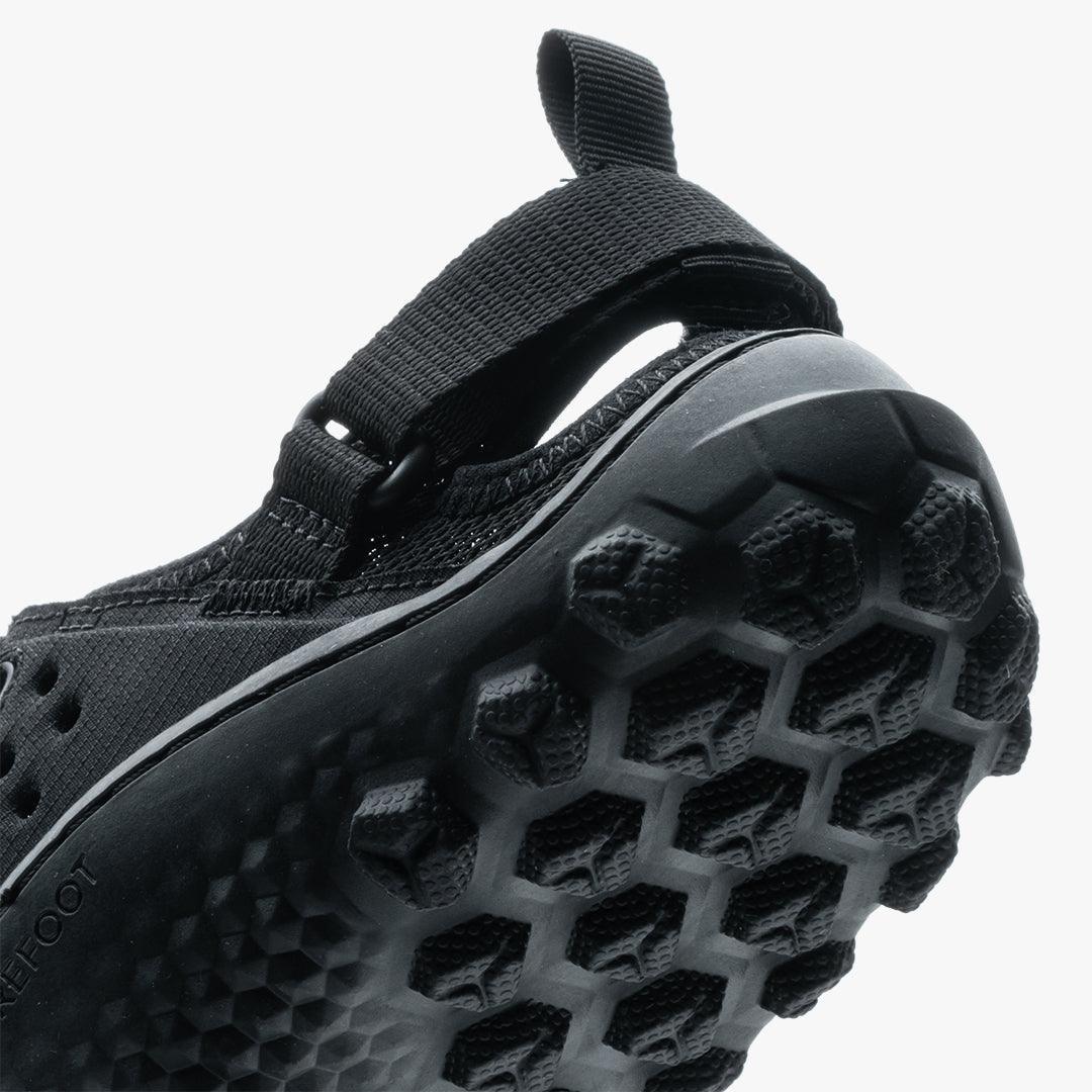 Close-up of black Vivobarefoot Tracker men's sandal sole with hexagonal tread pattern and strap detail