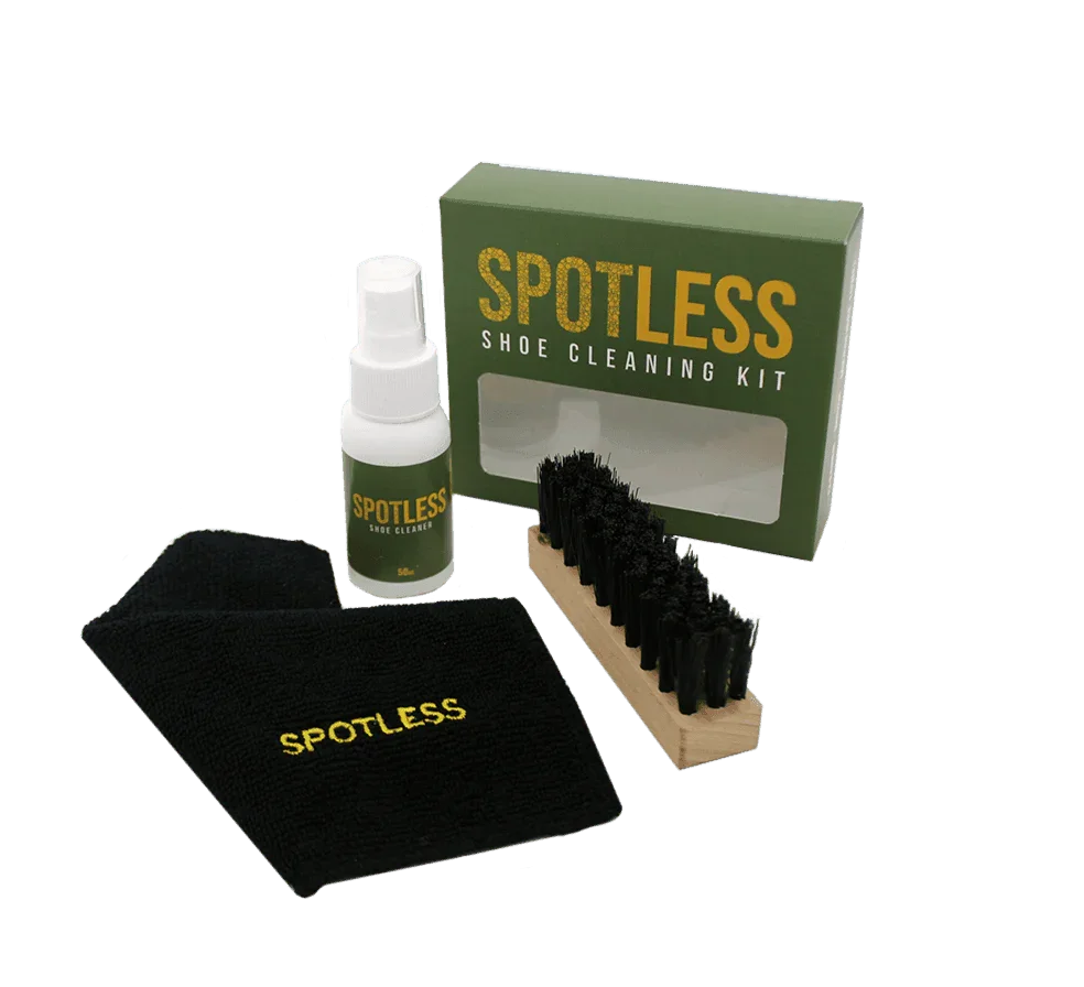 Spotless shoe cleaning kit with green box, spray bottle, black brush, and microfiber cloth
