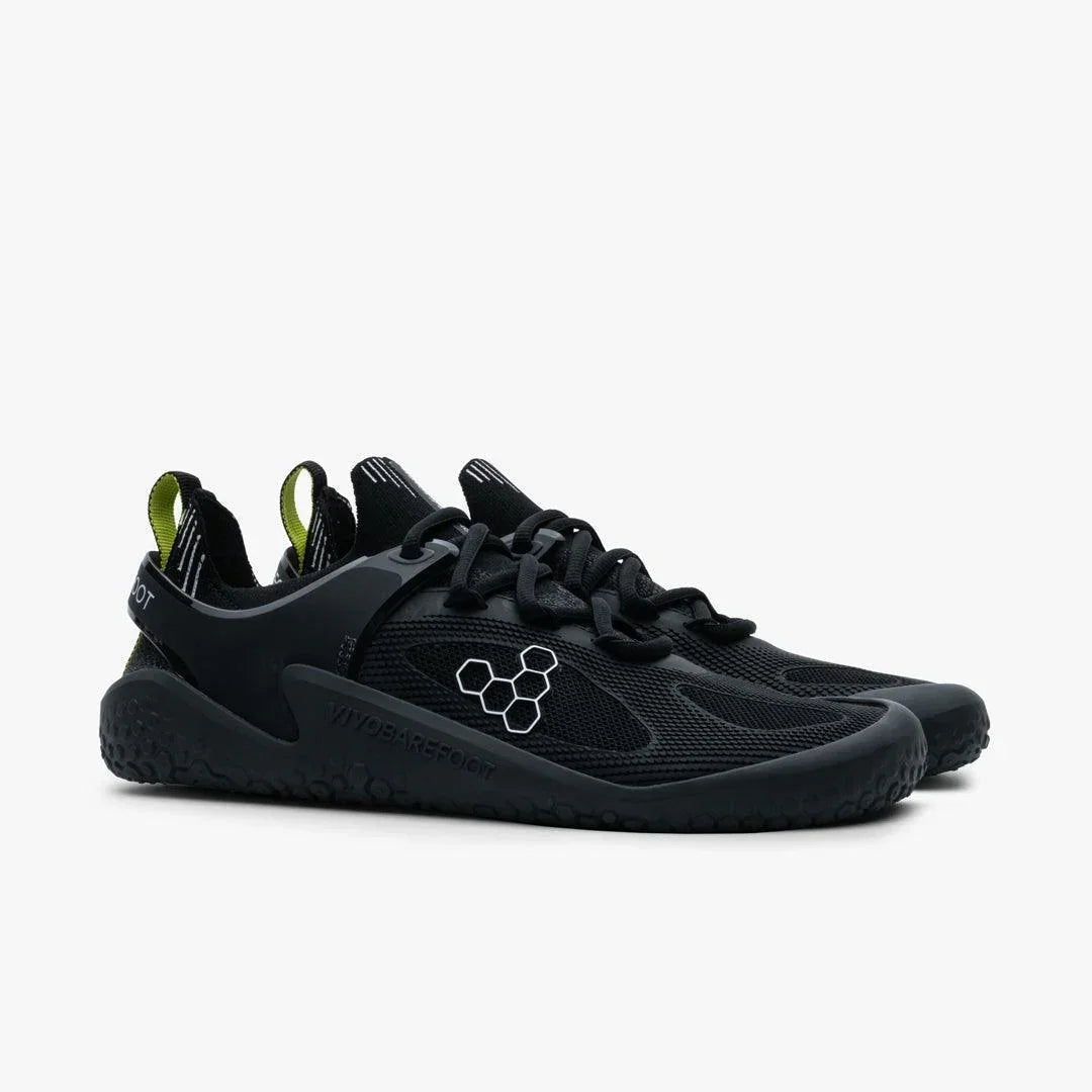 Pair of black Vivobarefoot Motus Strength men's sneakers with honeycomb logo on side