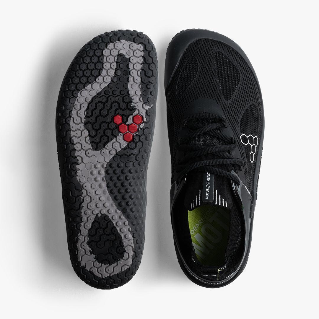 Top view of black Vivobarefoot Motus Strength men's shoes showing mesh upper and textured outsole with red hexagon accents